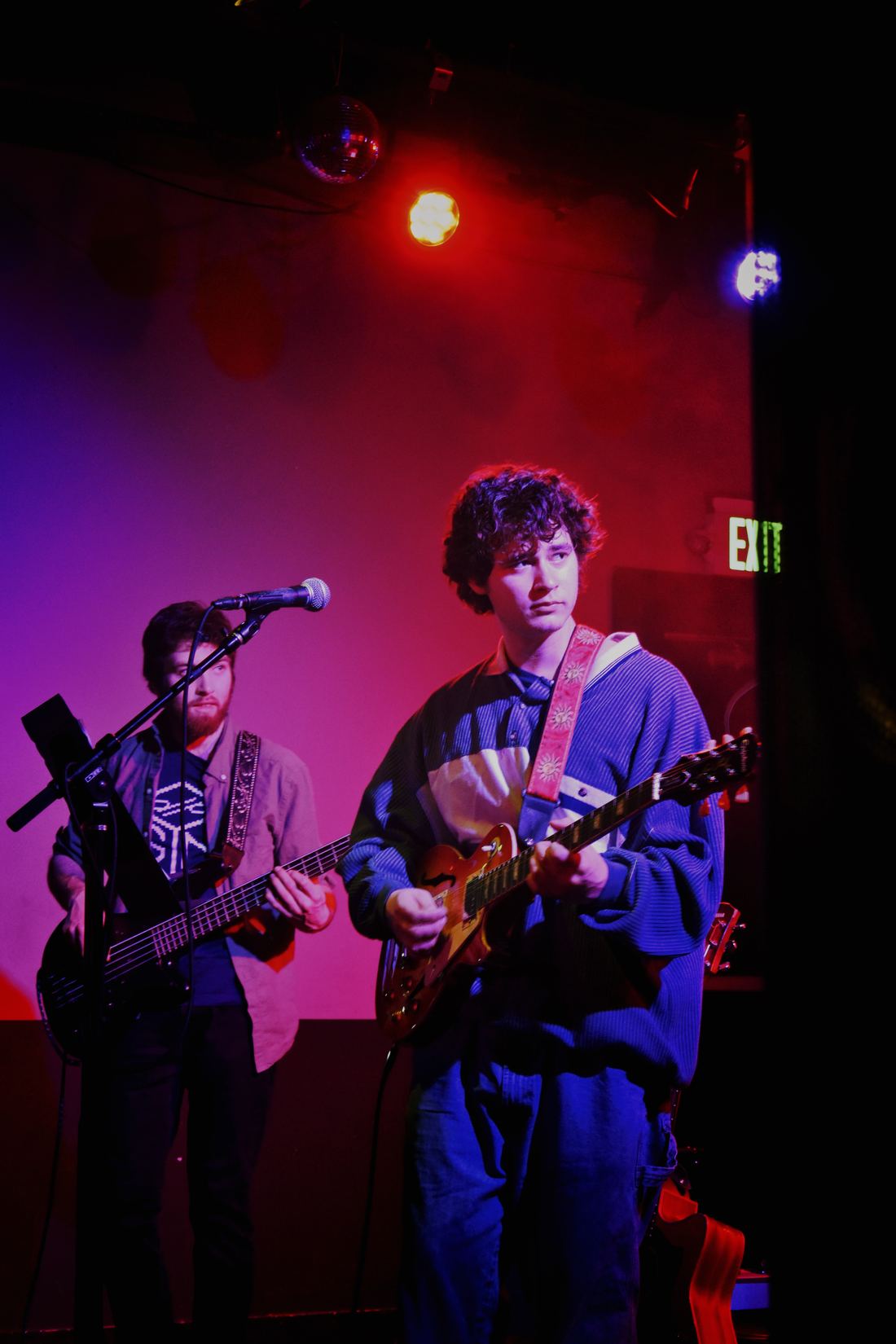 Two guitarists under red and blue lights