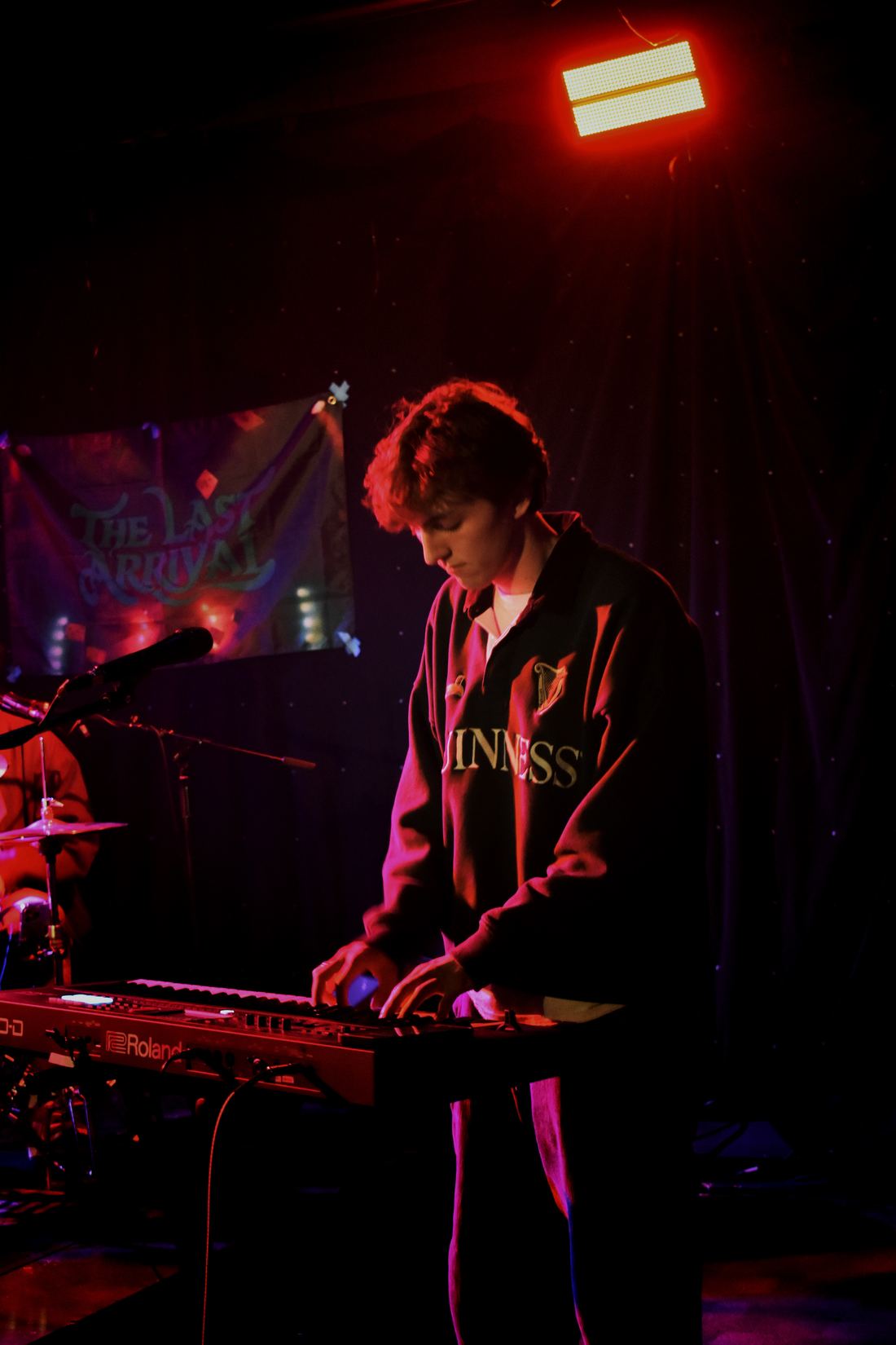 Guitarist mid-song in red stage light