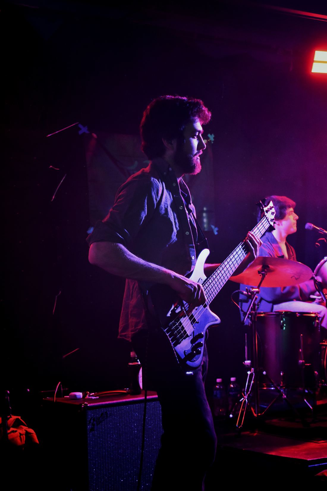 Guitarist mid-song in magenta light