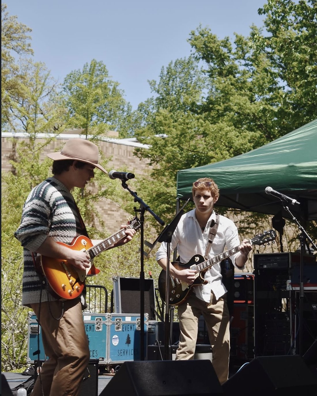 Two guitarists playing an outdoor set in daylight